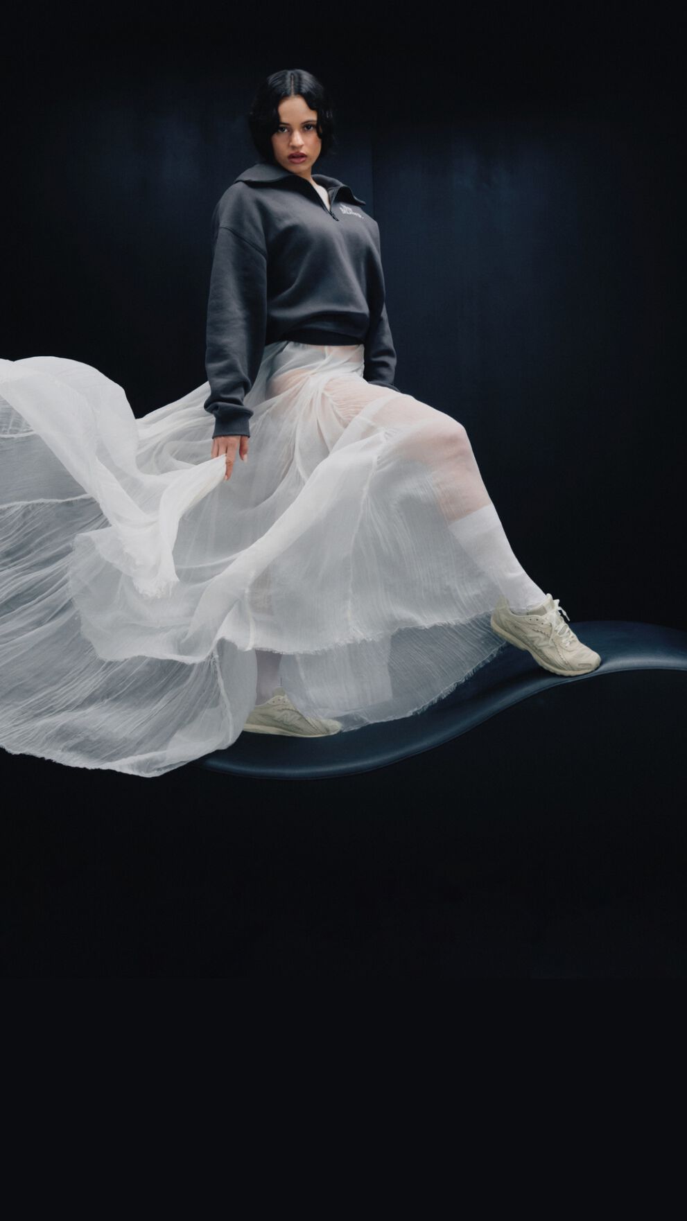 Rosal&iacute;a standing in front of a black studio backdrop. 